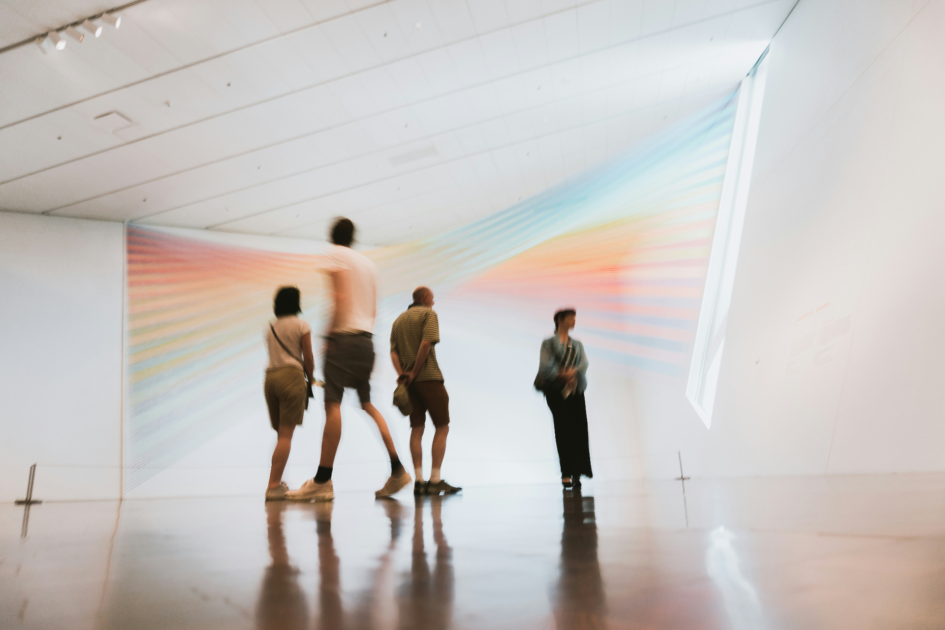 People moving through a luminous gallery installation